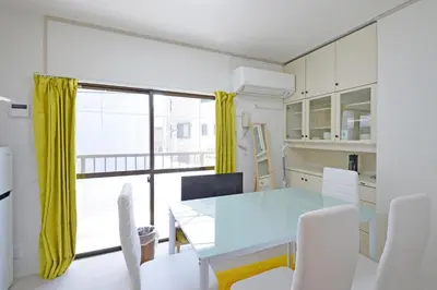 a dining room with a blue table and white chairs at Oji Natural Cosy House in Tokyo