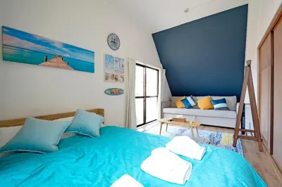 a bedroom with a blue bed and a couch at Oji Natural Cosy House in Tokyo