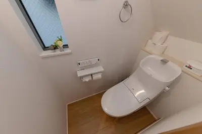 a white bathroom with a toilet and a window at Sky Tree house in Tokyo