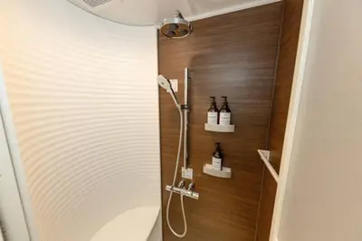 a bathroom with a shower with bottles on the wall at Sky Tree house in Tokyo