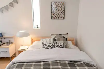 a bedroom with a bed and a table with a lamp at Sky Tree house in Tokyo