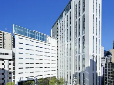 a tall white office building in a city at Shinjuku Granbell Hotel in Tokyo