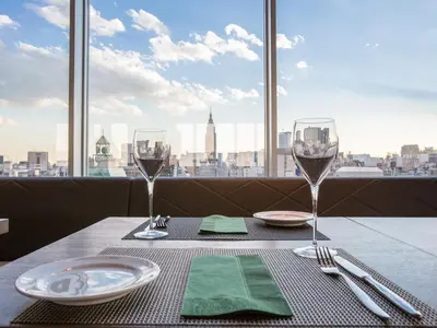 a table with wine glasses and a view of the city at Shinjuku Granbell Hotel in Tokyo