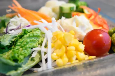 a salad with corn and vegetables on a plate at Shinjuku Granbell Hotel in Tokyo