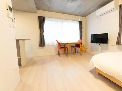 a bedroom with a table and a bed and a television at \u30e9\u30d5\u30a3\u30c3\u30c8\u4e21\u56fd in Tokyo