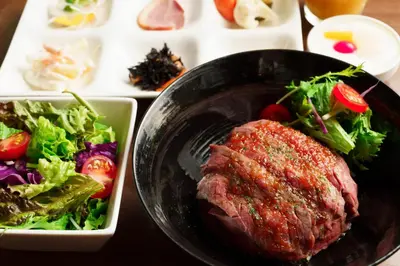 a plate of food with a steak and salad on a table at Hotel Sunroute Asakusa in Tokyo