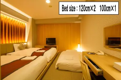 a hotel room with two beds and a desk at Hotel Sunroute Asakusa in Tokyo