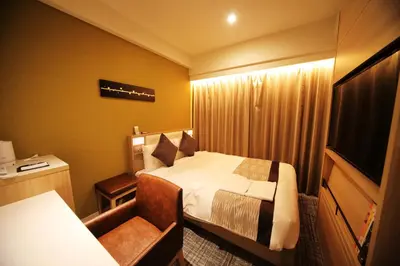 a hotel room with a bed and a chair at Hotel Sunroute Asakusa in Tokyo