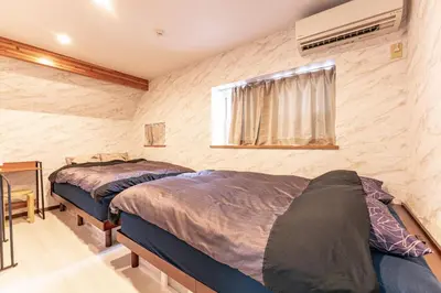 two beds in a room with a window at Grand Piano & Shinjuku 5min walk from station in Tokyo