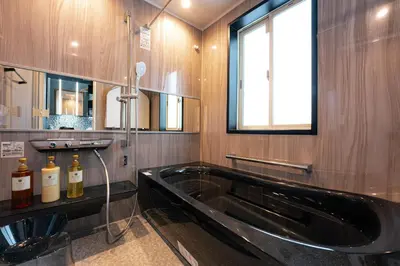 a bathroom with a black tub and a window at Grand Piano & Shinjuku 5min walk from station in Tokyo