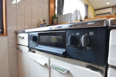 a black microwave sitting on top of cabinets in a kitchen at Sasatsuka Fleur Tachibana Hotel Apartment in Tokyo