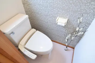 a bathroom with a toilet with a phone next to it at Sasatsuka Fleur Tachibana Hotel Apartment in Tokyo