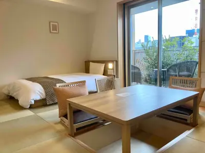 a room with a table and a bed and a window at Dormy Inn Premium Ginza - Natural Hot Spring in Tokyo