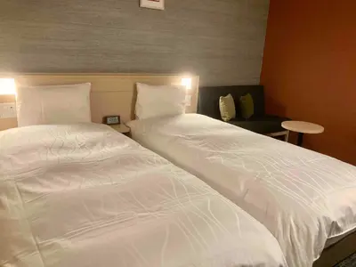two beds sitting next to each other in a room at Dormy Inn Premium Ginza - Natural Hot Spring in Tokyo