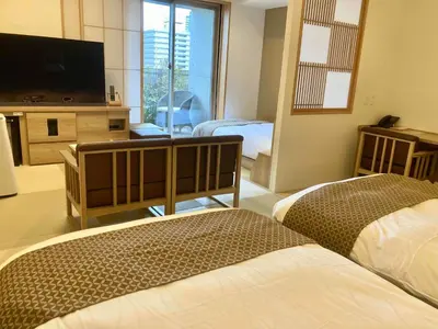 a hotel room with two beds and a flat screen tv at Dormy Inn Premium Ginza - Natural Hot Spring in Tokyo