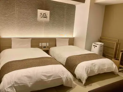 two beds sitting next to each other in a room at Dormy Inn Premium Ginza - Natural Hot Spring in Tokyo