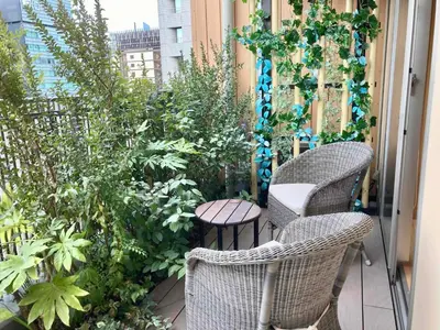 a balcony with chairs and plants on a building at Dormy Inn Premium Ginza - Natural Hot Spring in Tokyo