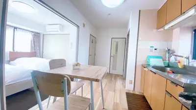 a room with a bed and a table and a kitchen at Esperanza 204\u53f7\u5ba4 in Tokyo