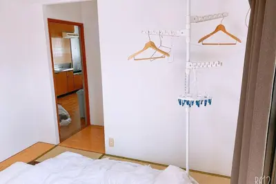a room with a white wall with hangers at Esperanza 204\u53f7\u5ba4 in Tokyo