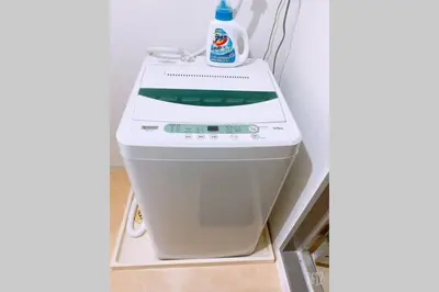 a washing machine in a corner of a room at Esperanza 204\u53f7\u5ba4 in Tokyo