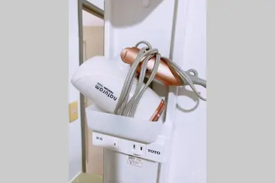 a white hair dryer hanging from a wall at Esperanza 204\u53f7\u5ba4 in Tokyo