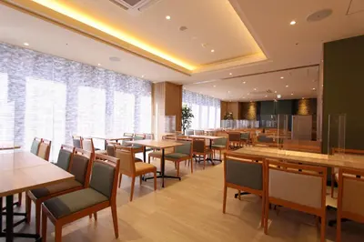 a restaurant with tables and chairs and a large window at KOKO HOTEL Tsukiji Ginza in Tokyo