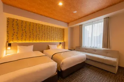 a hotel room with two beds and a couch at Tosei Hotel Cocone Asakusa in Tokyo
