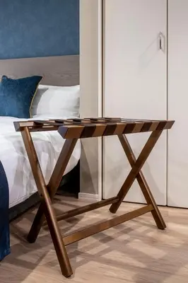 a wooden table sitting next to a bed at hotel aima in Tokyo