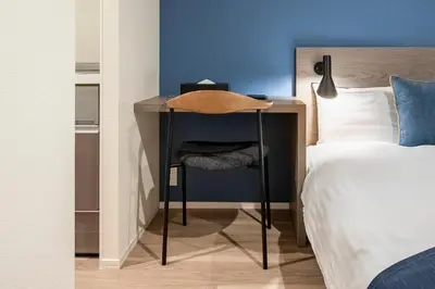 a desk with a chair next to a bed at hotel aima in Tokyo
