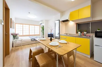 a kitchen and dining room with a wooden table and yellow cabinets at \u5bc5\u30db\u30c6\u30eb \u53f0\u6771 Hotel \u5bc5 \u53f0\u4e1c Tora Hotel Taito D in Tokyo