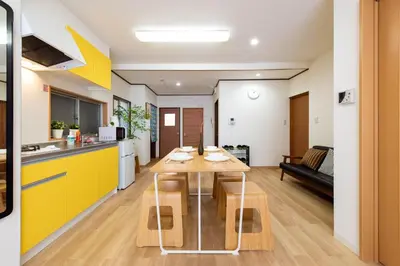 a kitchen and living room with a wooden table and yellow cabinets at \u5bc5\u30db\u30c6\u30eb \u53f0\u6771 Hotel \u5bc5 \u53f0\u4e1c Tora Hotel Taito D in Tokyo