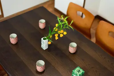 a wooden table with a vase of flowers on it at \u5bc5\u30db\u30c6\u30eb \u53f0\u6771 Hotel \u5bc5 \u53f0\u4e1c Tora Hotel Taito D in Tokyo