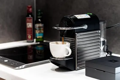 a coffee maker is making a cup of coffee at Oakwood Hotel & Apartments Azabu Tokyo in Tokyo