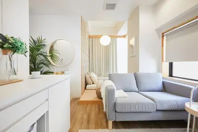 a living room with a blue couch and a window at Designers Hotel Siesta in Tokyo