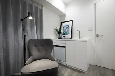 a room with a chair and a desk with a lamp at Designers Hotel Siesta in Tokyo