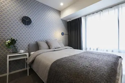 a bedroom with a bed and a clock on the wall at Designers Hotel Siesta in Tokyo