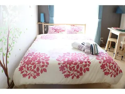 a bedroom with a bed with pink flowers on it at Maison Cresta Urayasu - Vacation STAY 11150 in Urayasu
