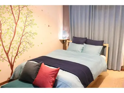 a bedroom with a bed with a tree on the wall at Maison Cresta Urayasu - Vacation STAY 11150 in Urayasu