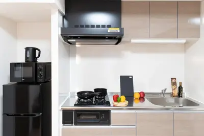 a kitchen with a black refrigerator and a sink at BON Tokyo Asakusa in Tokyo