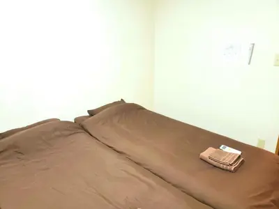 a brown bed with a purse on top of it at Within walking distance of Disneyland! - Vacation STAY 11473 in Urayasu