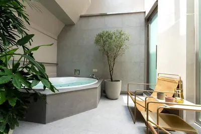 a bathroom with a tub with a potted plant at hotel hisoca ikebukuro in Tokyo