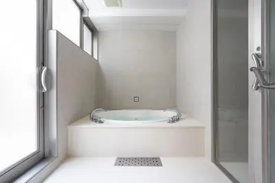a bathroom with a bath tub next to a window at hotel hisoca ikebukuro in Tokyo