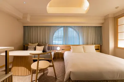 a hotel room with two beds and a table at hotel hisoca ikebukuro in Tokyo