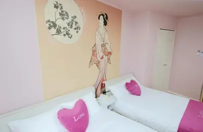 two beds in a room with pink and white pillows at \u6b66\u8535Musashi Hotel in Tokyo