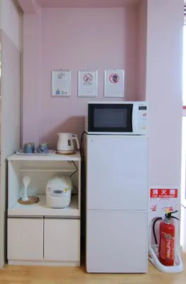 a small kitchen with a microwave and a refrigerator at \u6b66\u8535Musashi Hotel in Tokyo