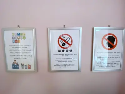 three signs are hanging on a wall at \u6b66\u8535Musashi Hotel in Tokyo