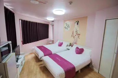 two beds in a room with pink walls and a tv at \u6b66\u8535Musashi Hotel in Tokyo