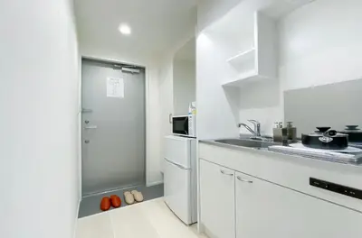 a white kitchen with a refrigerator and a sink at japan house shinkoiwa in Tokyo