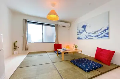 a living room with a table and red chairs at japan house shinkoiwa in Tokyo