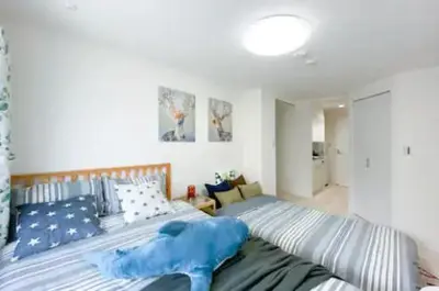 a bedroom with a large bed with blue sheets at japan house shinkoiwa in Tokyo